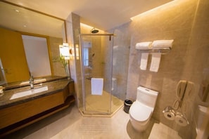 A modern bathroom with a glass-enclosed shower, a large mirror, a sink with a marble countertop, and a toilet with a towel rack. - Wen Gong Hotel (Youxi)