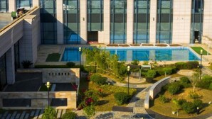 A modern building with a swimming pool surrounded by landscaped gardens and pathways. - Wen Gong Hotel (Youxi)