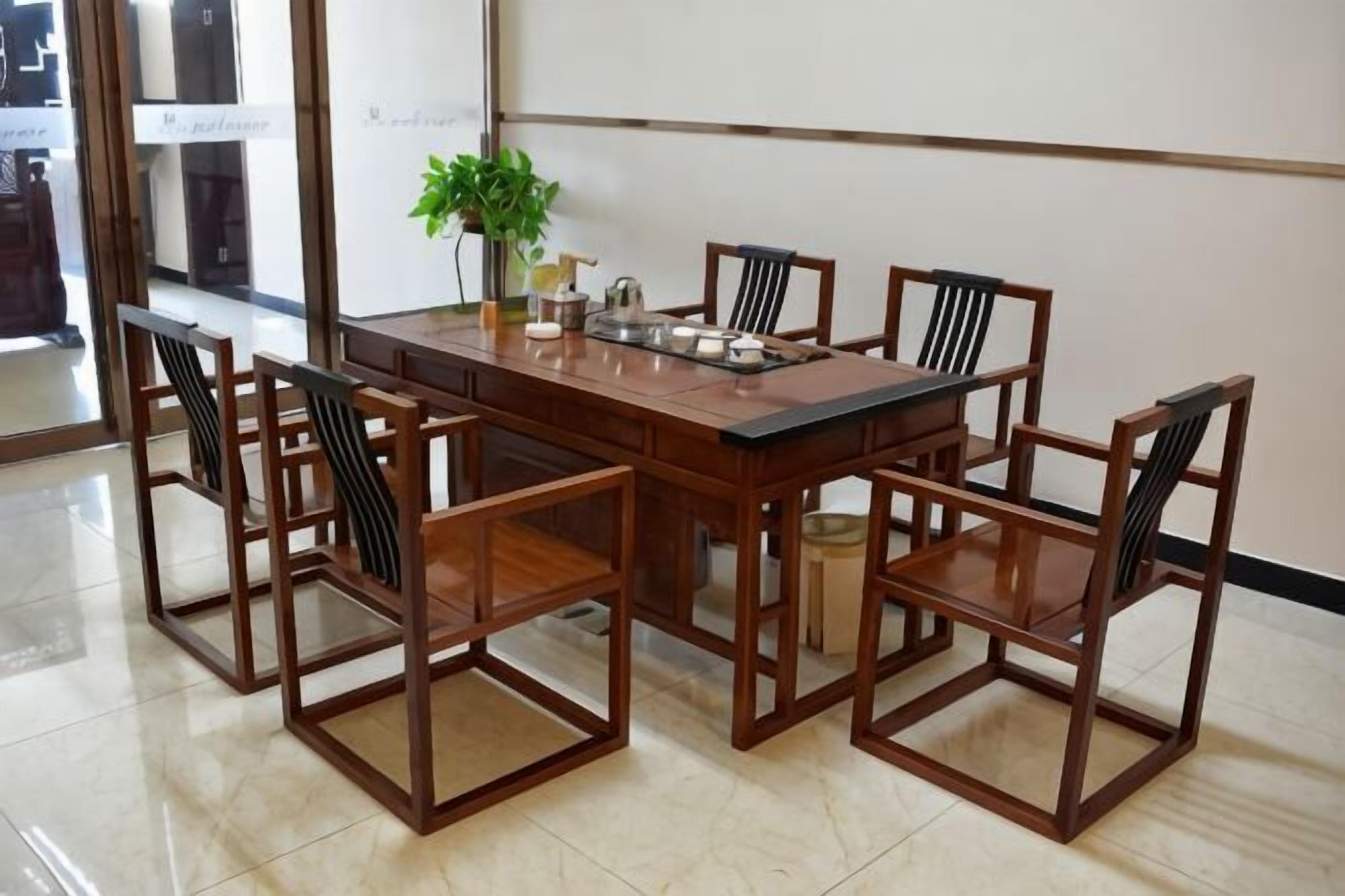 A conference room with a rectangular table and six chairs, a potted plant, and a whiteboard.