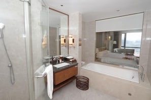 A modern bathroom with a glass-enclosed shower, a wooden vanity with a sink, a large mirror, and a bathtub. - Wen Gong Hotel (Youxi)
