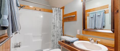 A bathroom with a bathtub, toilet, and sink.