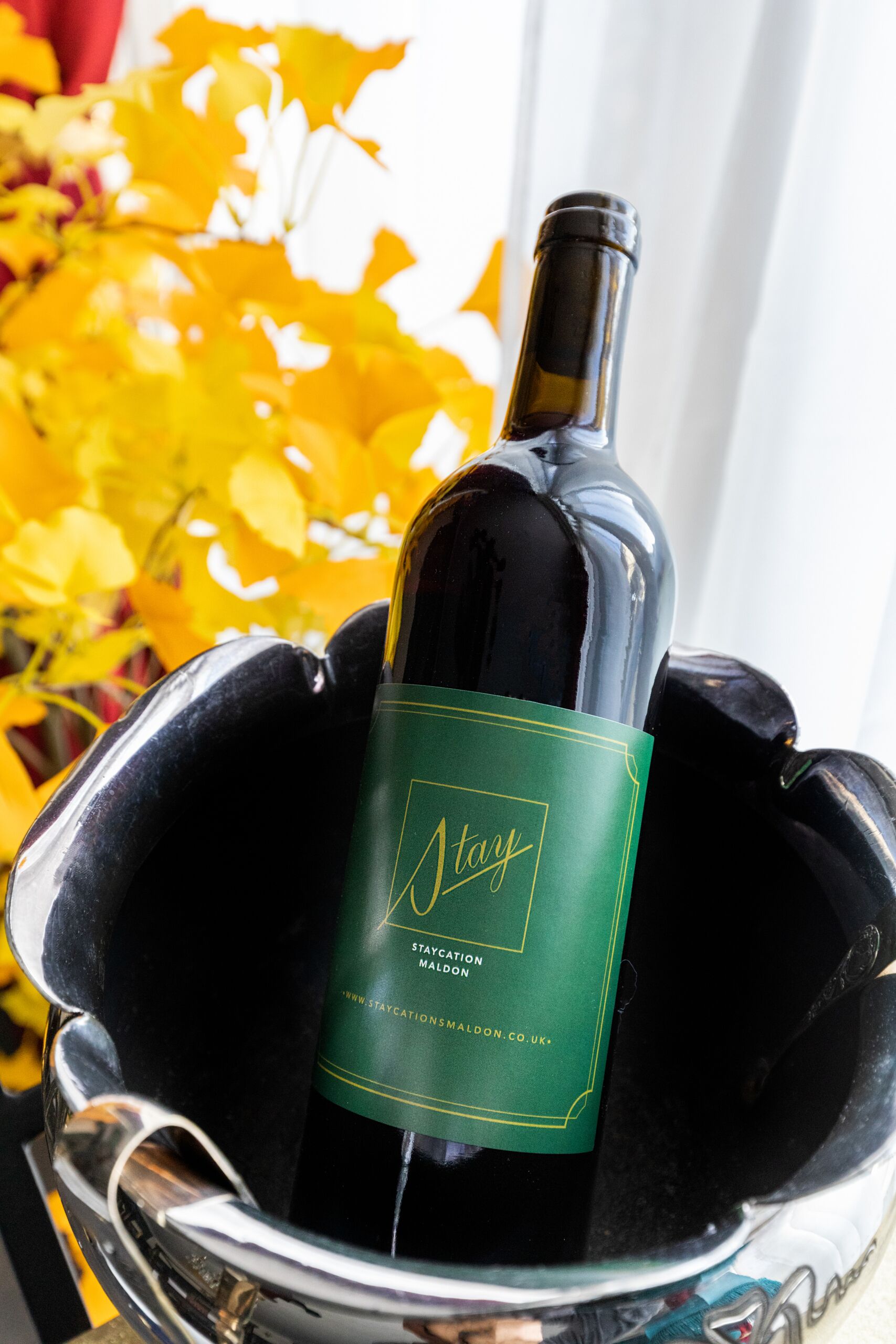 A bottle of wine in a metallic bucket with a green label.