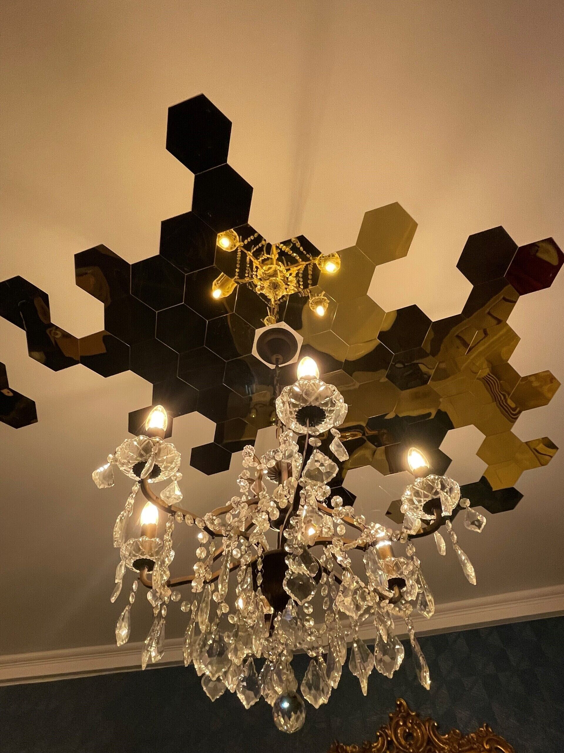 A chandelier with crystal decorations and a geometric ceiling design.