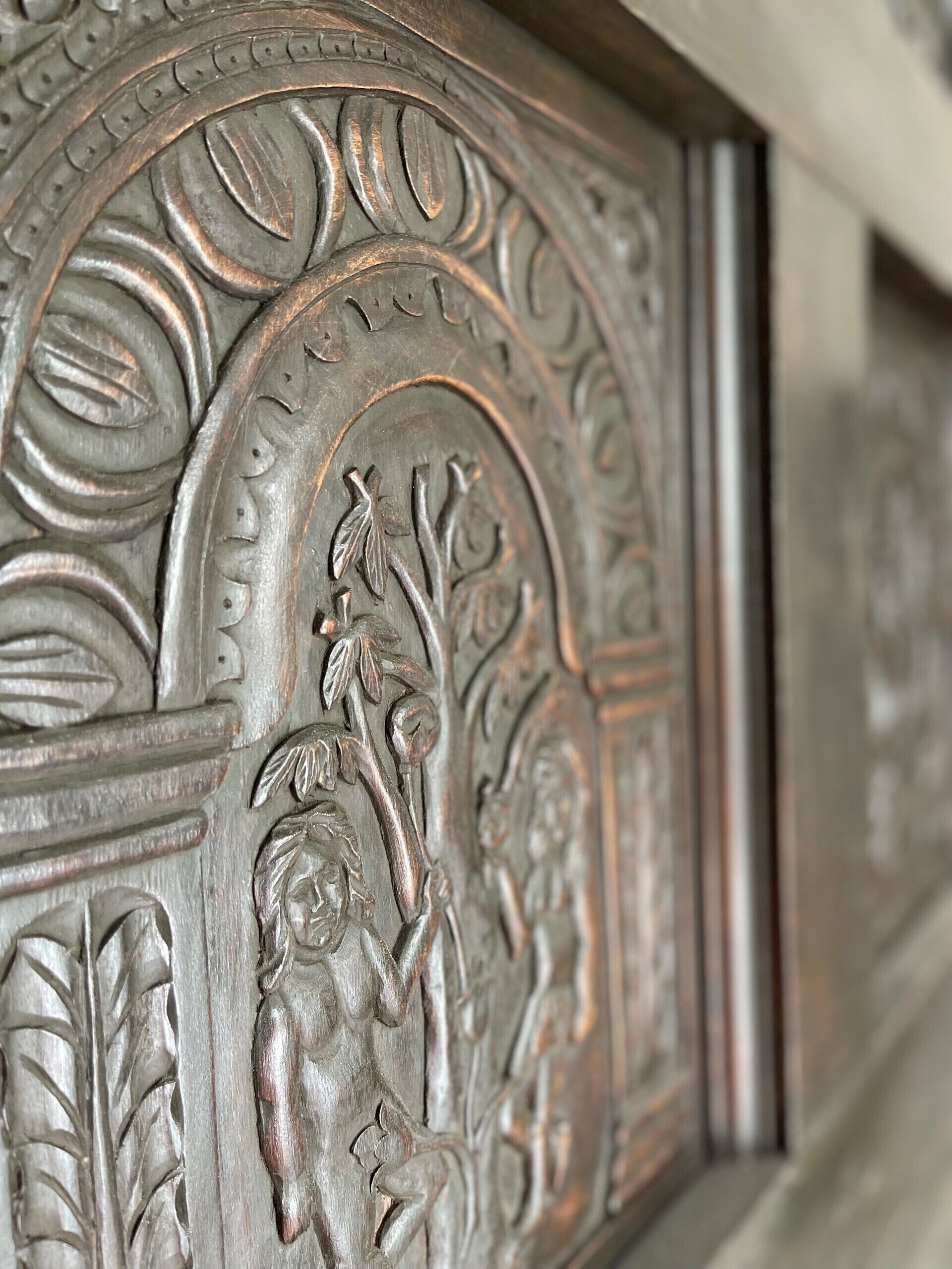 A detailed metal relief with floral and leaf patterns, possibly part of a building's facade or architectural element.