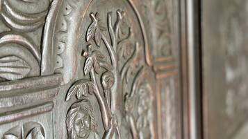 A detailed metal relief with floral and leaf patterns, possibly part of a building's facade or architectural element.
