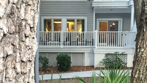 A two-story house with a balcony, a small garden, and a tree in the foreground. -  Poolside #, Westin Amenities Included with your stay.  #133 (Hilton Head Island)