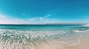 A beach with clear turquoise water, a sandy shore, and a pier extending into the sea. - Perfect Beach Getaway Near 30A, Sunnyside & PCB! (Panama City Beach)