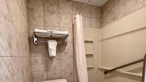 Un bagno con il water, una doccia con porta in vetro e un portasciugamani con un asciugamano.