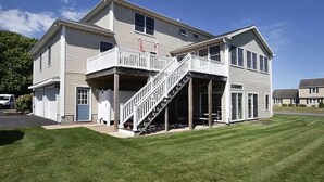 A two-story building with a balcony and a staircase leading to the upper floor. - Book Now for Fun  in the Sun! Spring  & Summer 2026  (Narragansett)