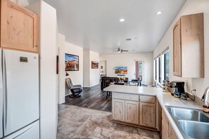 A modern kitchen with wooden cabinets, a central island, and a built-in sink.