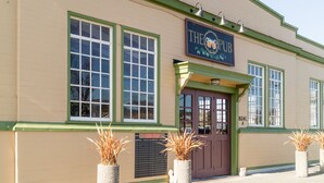 Ein Gebäude mit einem Schild, auf dem "THE PUB" steht, und einer Tür mit dem Schild "GEÖFFNET".