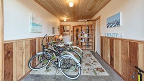 Ein Flur mit Holzwänden und -decke, einem Sauna-Schild, einem Bücherregal und Fahrrädern.