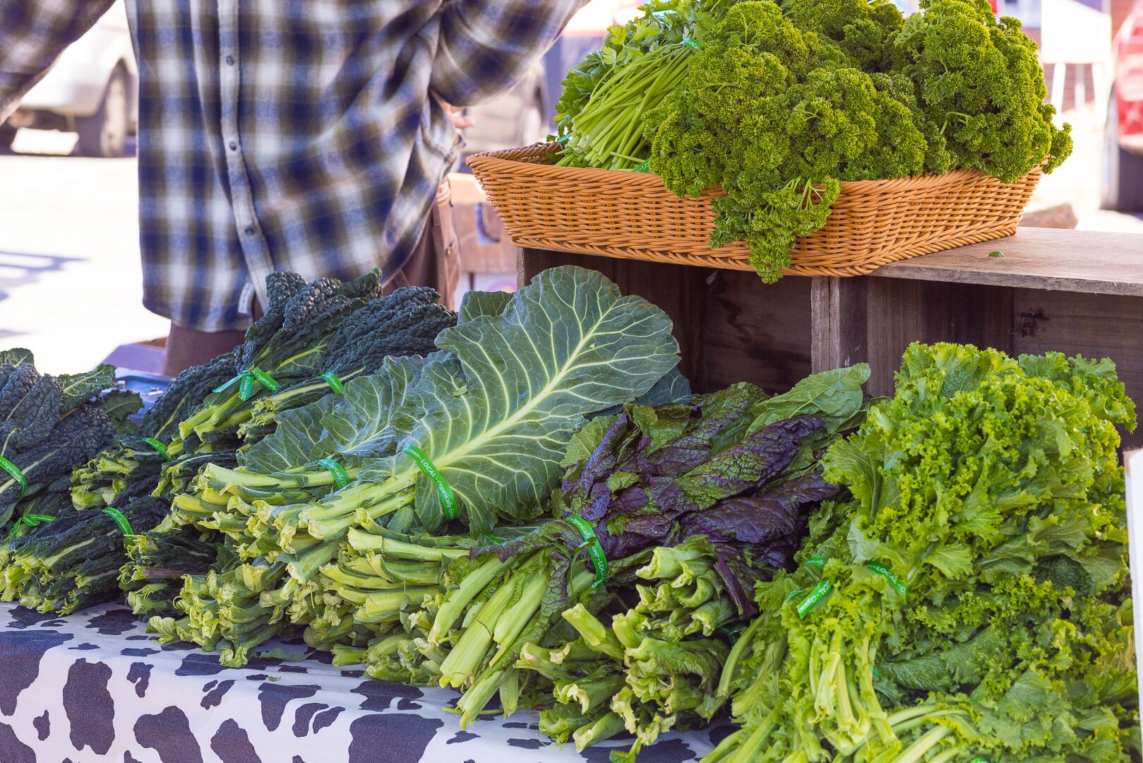 A variety of leafy greens displayed on a table at a market.