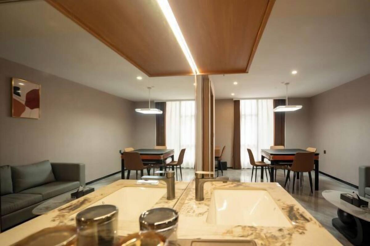A modern living room with a dining area, a sofa, a coffee table, and a large marble table.