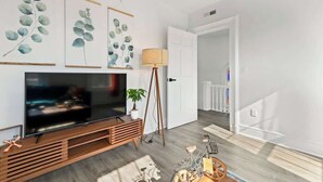 Ein modernes Wohnzimmer mit Flachbildfernseher, Holz-Unterhaltungseinheit und Wandbild.