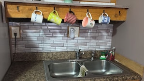 Una cocina con encimera de granito, pileta doble y armarios de madera.