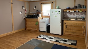Una cocina compacta con armarios de madera, un refrigerador, una estufa y un microondas.
