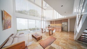 Àmplia zona d'estar amb cuina moderna, menjador i finestra gran que deixa entrar molta llum natural.