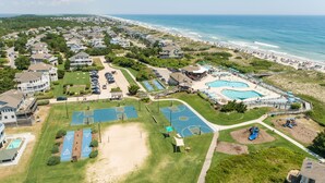 An aerial view of a coastal residential area with houses, a beach, and a community pool complex. - Corolla Light Escape - Hot Tub + Beach Gear + Sunsets + Wifi (Corolla)