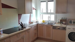 A kitchen with a dishwasher, sink, and a washing machine.