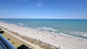 Een strand met helder uitzicht op de oceaan en een pad naar het strand.
