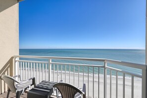 A balcony with a view of the ocean, featuring two chairs and a table. - HS-1205 12th Fl Oceanfront | Amazing Sunrise Views (Myrtle Beach)