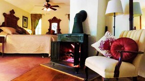 A cozy room with a fireplace, a bed, a chair, and a lamp.