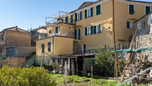 A multi-story building with balconies and a garden area in front. - Apartment Verde by Interhome (Vasia)
