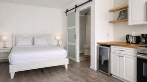 A bedroom with a bed, bedside tables, and a sliding door leading to a bathroom. - South Sunrise Studio - Retreat in Forks (Forks)