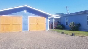 A two-story building with a blue exterior and a gravel driveway. - South Sunrise Studio - Retreat in Forks (Forks)