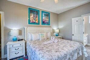 A bedroom with a bed, two nightstands, a dresser, and two wall-mounted paintings.