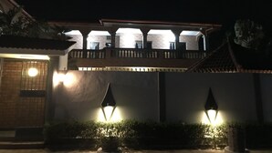 Un bâtiment doté d’un balcon et de deux lampes fixées au mur.
