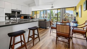 Eine moderne Küche mit einer zentralen Kochinsel, Barhocker und einem Essbereich mit Holzkästen.