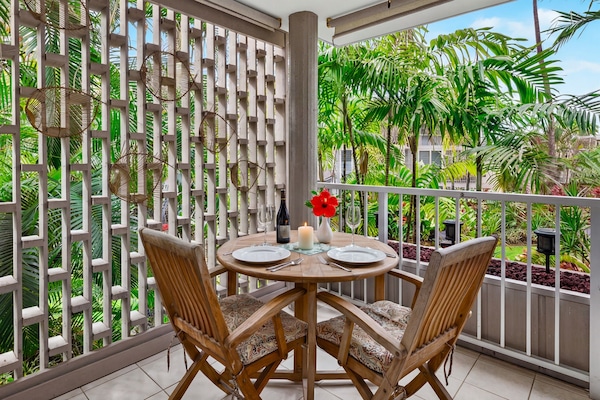 Private lanai dining area surrounded by lush tropical greenery—an inviting spot for morning coffee or a quiet meal outdoors.