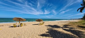 Na praia, espreguiçadeiras, toalhas de praia 