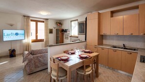 Un espacio habitable compacto con comedor, kitchenette y sofá.