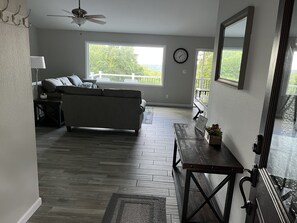 Un salon avec un canapé, une table et une horloge au mur.