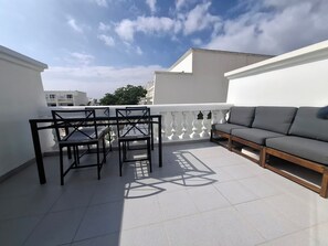 A balcony with a table and chairs, a sofa, and a white railing. - Loma Verde Puerto del Carmen (Puerto del Carmen)