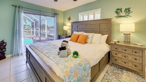 Un dormitorio con cama, mesitas de noche, ventilador de techo y vistas al exterior.