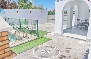 Relax by the pool surrounded by lush surroundings and enjoy the patio's outdoor seating area.