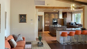 A spacious living area with a sofa, coffee table, and a kitchen in the background. - Spacious Ranch House Sedona  (Sedona)