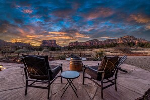 Un espace extérieur aménagé avec deux chaises et une table, offrant une vue sur un paysage montagneux.