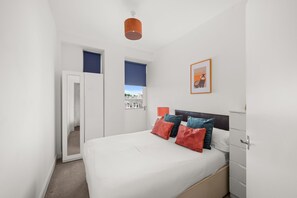 Une chambre à coucher avec un lit, une armoire, une porte et une fenêtre.