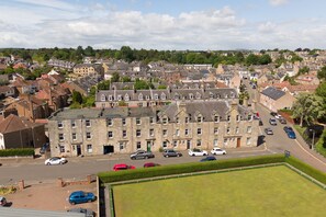 Un quartier résidentiel avec des immeubles à plusieurs étages, une rue principale et des voitures garées.