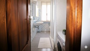 A narrow hallway leading to a bathroom with a sink, mirror, and a small plant on the counter. - Apartment with A/C 250m from beach | Ap19 (Diano Marina)
