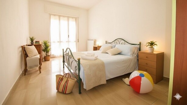 Un dormitorio con cama, mesitas de noche, una silla, una ventana y una pelota de playa.
