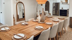 Una sala da pranzo moderna con un tavolo in legno apparecchiato per sei persone, circondato da sedie.