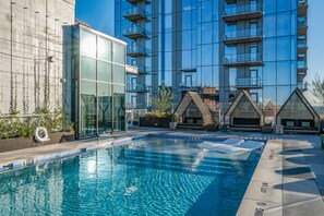 Relax by the rectangular pool surrounded by a tiled deck and lounge chairs.