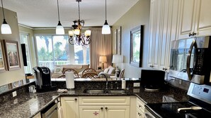 A kitchen with white cabinets, a granite countertop, a stainless steel range, and a built-in oven. - Beautiful Owner Managed Condo at the Crescent - Best Complex in Destin (Miramar Beach)