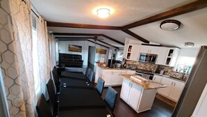 A modern kitchen with white cabinets, a granite countertop, and stainless steel appliances.